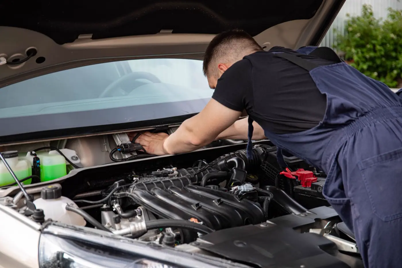 Mecanicien qui vérifié le compartiment moteur d'une voiture